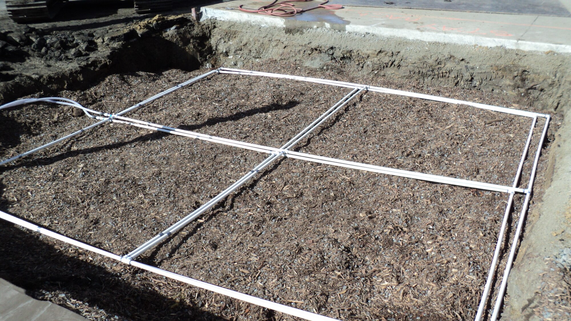 Two PVC distribution manifolds pump contiminated groudwater into the bioreactor. Small holes at the bottom of the manifold ensure the water is evenly distributed over the gravel and mulch mixture. A geotextile layer will protect the manifold and prevent the holes from getting plugged. (Photo courtesy of CH2M Hill)