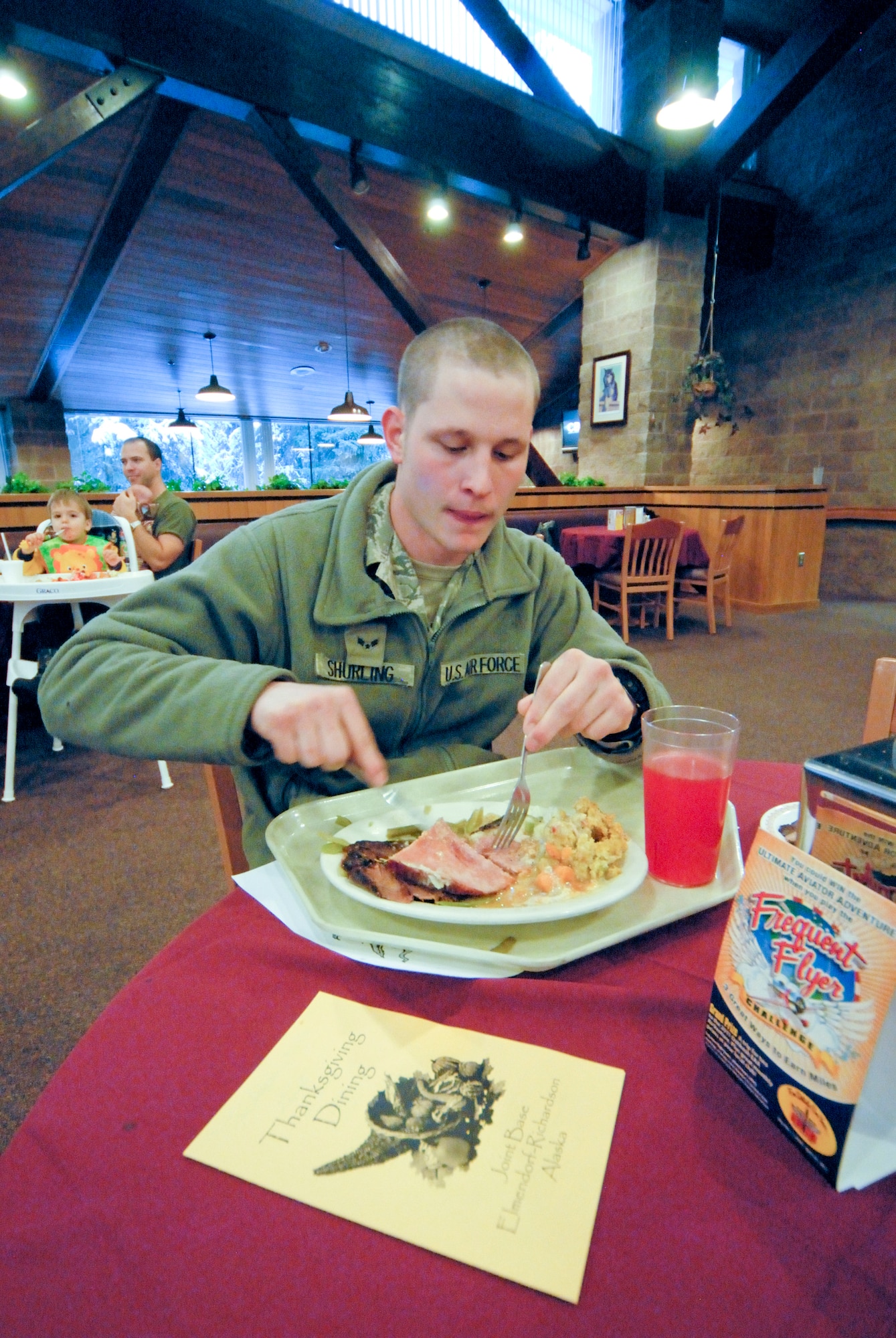 JOINT BAE ELMENDORF-RICHARDSON, Alaska -- Airman 1st Class Mike Shurling, 773rd Civil Engineering Squadron, takes a break to enjoy Thanksgiving meal at the Iditarod Dining Facility. The bountiful meal included choices of turkey, ham, stuffing and pie among other holiday favorites. (Photo by Steve White/JBER PAO)