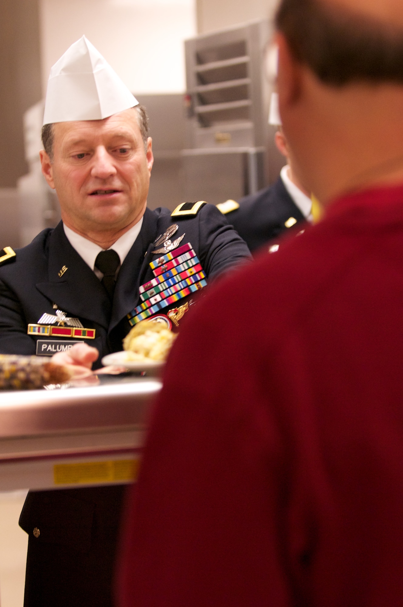 JOINT BASE ELMENDORF-RICHARDSON, Alaska -- Brig. Gen. Raymond Palumbo, U.S. Army Alaska commanding general, serves a Gold Rush Inn Dining Facility patron, Thanksgiving. Leadership representing base units served Thanksgiving meals in shifts. (Photo by David Bedard/JBER PAO)