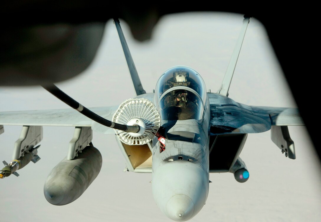 A U.S. Navy F/A-18 Hornet maneuvers in position behind a KC-10 Extender Nov. 25, 2010, during air refueling operations over the mountains of Afghanistan. The KC-10 is assigned to the 908th Expeditionary Air Refueling Squadron in support of operations Enduring Freedom and New Dawn. (U.S. Air Force photo/Staff Sgt. Andy M. Kin)