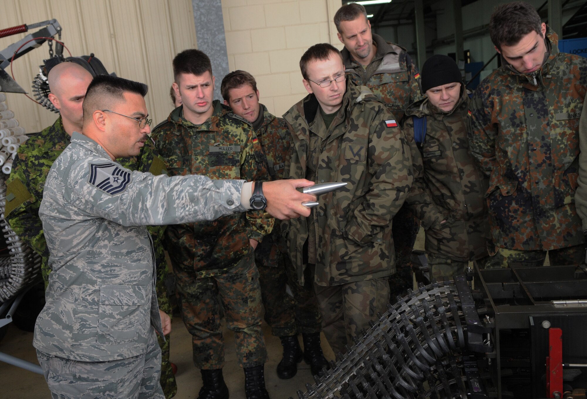 SPANGDAHLEM AIR BASE, Germany – Senior Master Sgt. Patrick Sebay, 52nd Equipment Maintenance Squadron Armament Flight superintendent, shows NATO visitors various munitions equipment Dec. 2. Members of NATO Headquarters Allied Air Command at Ramstein Air Base, Germany, visited the 52nd Fighter Wing to familiarize themselves with an American fighter wing and how it operates. (U.S. Air Force photo/Airman 1st Class Matthew B. Fredericks)