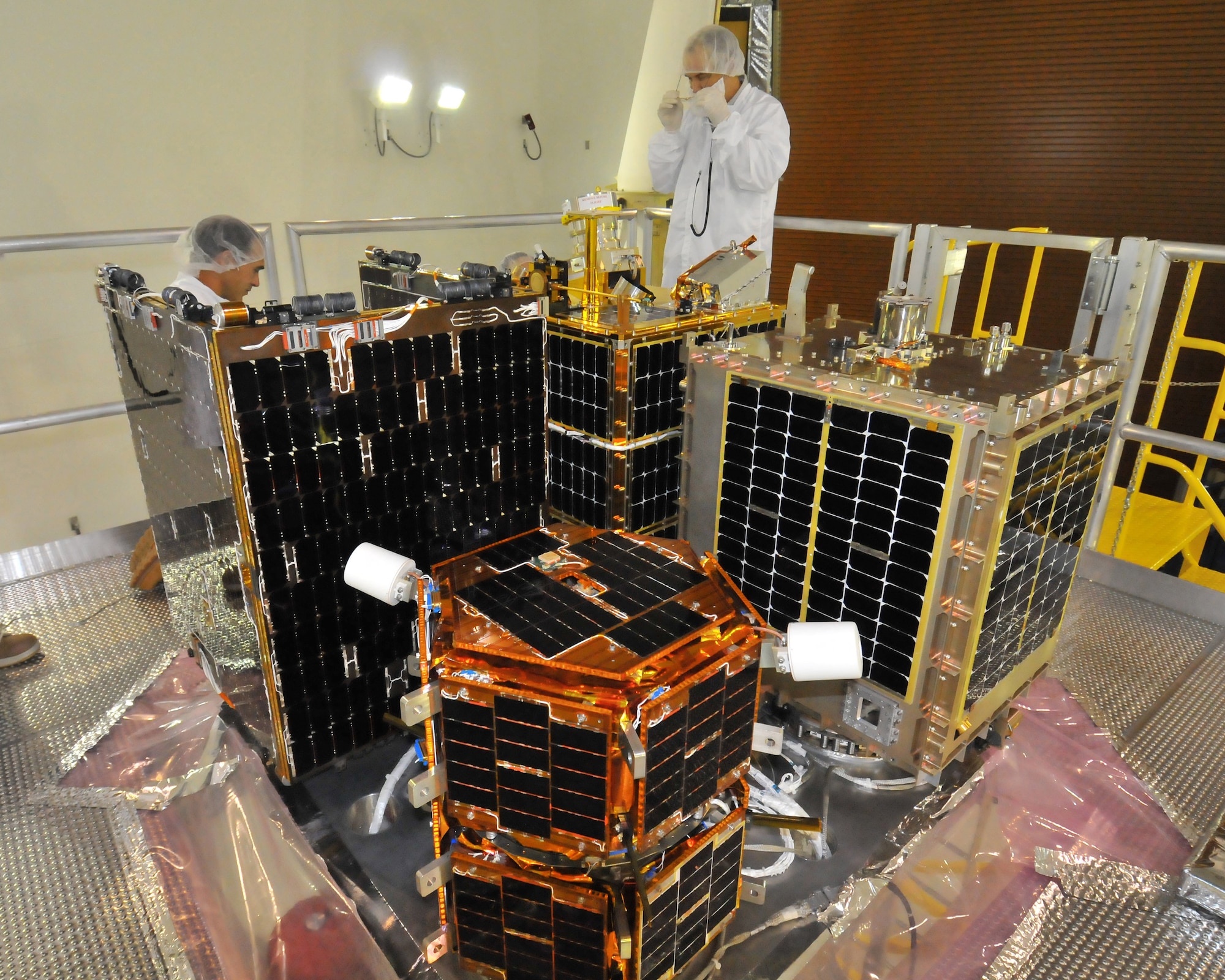 Scientists work on the four satellites sitting atop the Minotaur IV Launch Vehicle for the S26 mission.  Courtesy photo by Lou Hernandez