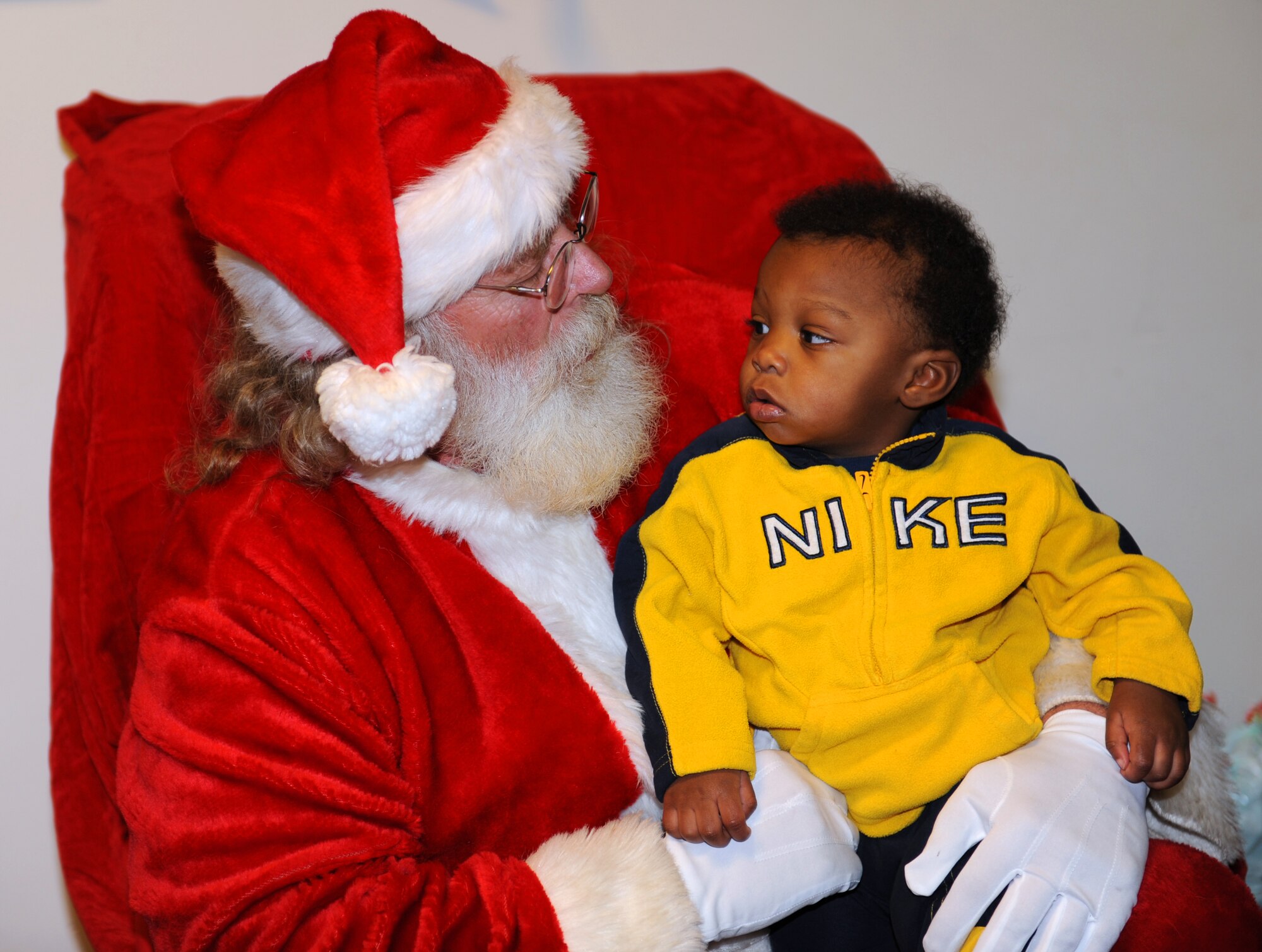 ELLSWORTH AIR FORCE BASE, S.D. -- Micah Oliver, son of Zanobia Oliver, stares into the eyes of Santa Claus during the base Christmas Tree Lighting event, Dec 1. The ceremony was hosted by Freedom Chapel and included events such as Christmas caroling, hot chocolate, and lighting the base Christmas tree. (U.S. Air Force photo/Master Sgt. Loren J. Bonser)