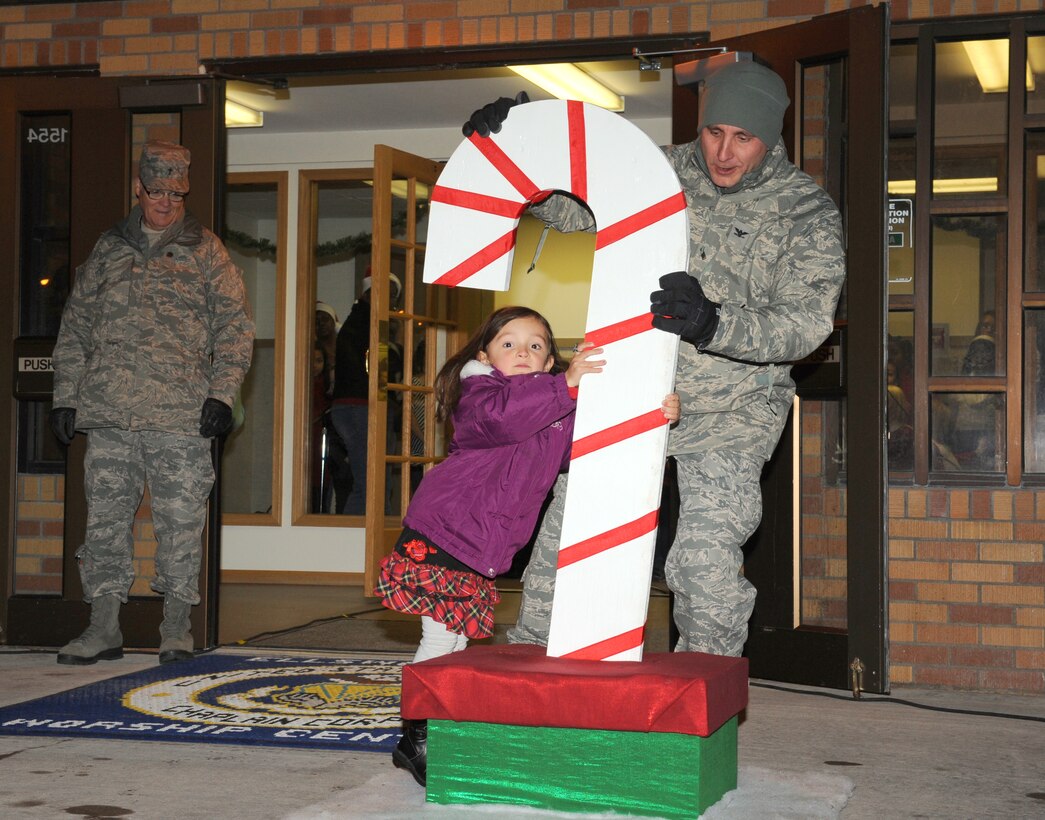 ELLSWORTH AIR FORCE BASE, S.D. -- Col. Jeffrey Taliaferro, 28th Bomb Wing commander, and Alyxiss Filkins push the switch to light the base Christmas tree during a ceremony, Dec. 1 at the Freedom Chapel. Alyxiss is the daughter of Airman 1st Class Curtis Filkins, 28th Communications Squadron, currently deployed to Southwest Asia. (U.S. Air Force photo/Master Sgt. Loren J. Bonser)