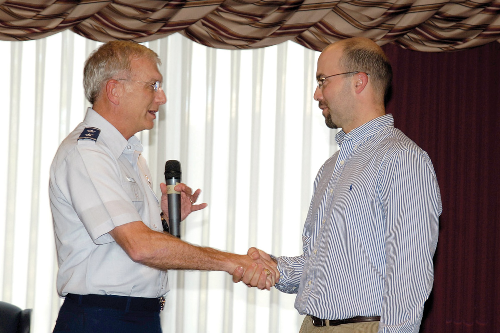 Maj. Gen. David Gillett, Oklahoma City Air Logistics Center commander, congratulates Sam Nowakowski for a job well done leading this year’s Combined Federal Campaign efforts. During the month-and-a-half long campaign, Team Tinker exceeded its goal by donating more than $2.1 million. (Air Force photo by Margo Wright)