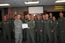 LAUGHLIN AIR FORCE BASE, Texas –First Lt. Russell Kingsbery, 85th Flying Training Squadron, poses with fellow members of his squadron after being presented the XLer of the Week award by Col. Michael Frankel, 47th Flying Training Wing commander, Dec. 1. The XLer is a weekly award chosen by 47th FTW leadership and given to individuals who consistently make outstanding contributions to Laughlin and their unit. (U.S. Air Force photo by Airman 1st Class Blake Mize)