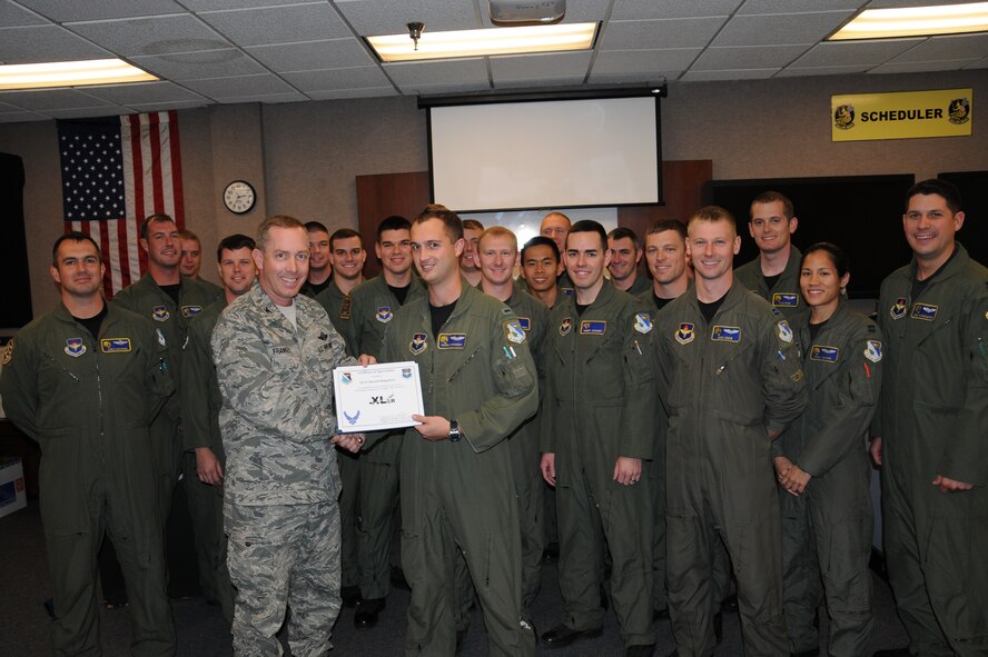 LAUGHLIN AIR FORCE BASE, Texas –First Lt. Russell Kingsbery, 85th Flying Training Squadron, poses with fellow members of his squadron after being presented the XLer of the Week award by Col. Michael Frankel, 47th Flying Training Wing commander, Dec. 1. The XLer is a weekly award chosen by 47th FTW leadership and given to individuals who consistently make outstanding contributions to Laughlin and their unit. (U.S. Air Force photo by Airman 1st Class Blake Mize)