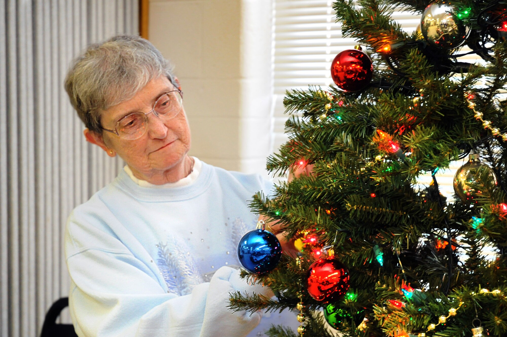 Lorraine Caddy volunteers in decorating a tree at the Tinker Chapel on Monday. The retired chief master sergeant was one of many volunteers who gathered at the chapel earlier this week to decorate for the holiday season. (Air Force photo by Margo Wright)