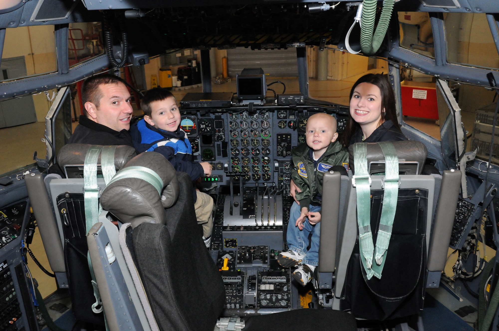 A local 3-year-old boy's dream came true when he reported to the 107th Airlift Wing for the day as an honorary pilot. Logan and his family check out all the gauges, switches and gadgets in the cockpit of a C-130. From left to right; Logan's father Marc, his brother Caiden, and his mother Carol.  (U.S. Air Force photo/Staff Sgt. Peter Dean)  