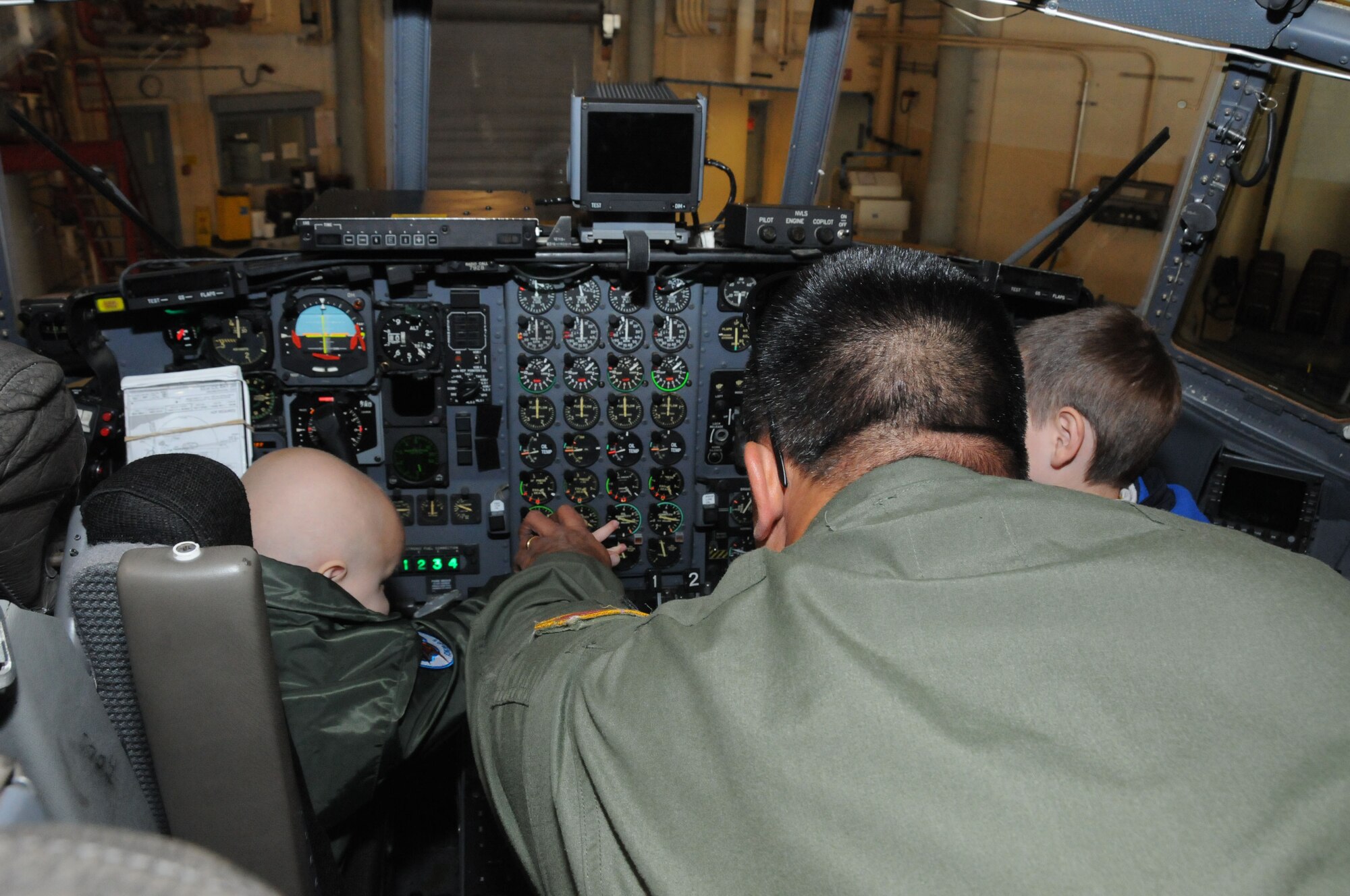 A local 3-year-old boy's dream came true when he reported to the 107th Airlift Wing for the day as an honorary pilot. Maj. Michael Galvin shows Logan the gadgets in the cock pit of a C-130. (U.S. Air Force photo/Staff Sgt. Peter Dean)  