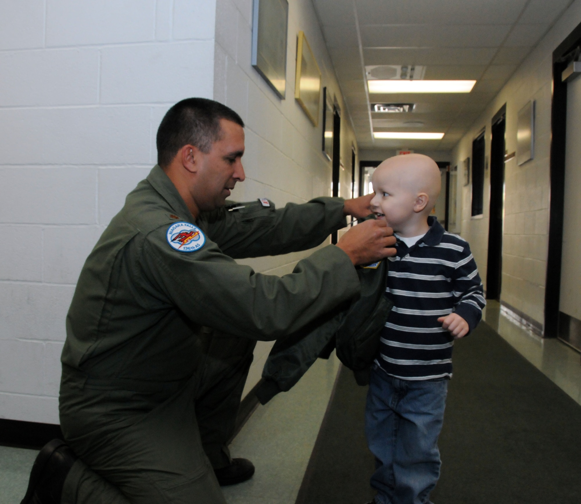 A local 3-year-old boy's dream came true when he reported to the 107th Airlift Wing for the day as an honorary pilot. Maj. Michael Galvin presents Logan with his very own flight jacket that included the appropriate patches. (U.S. Air Force photo/Staff Sgt. Peter Dean)  