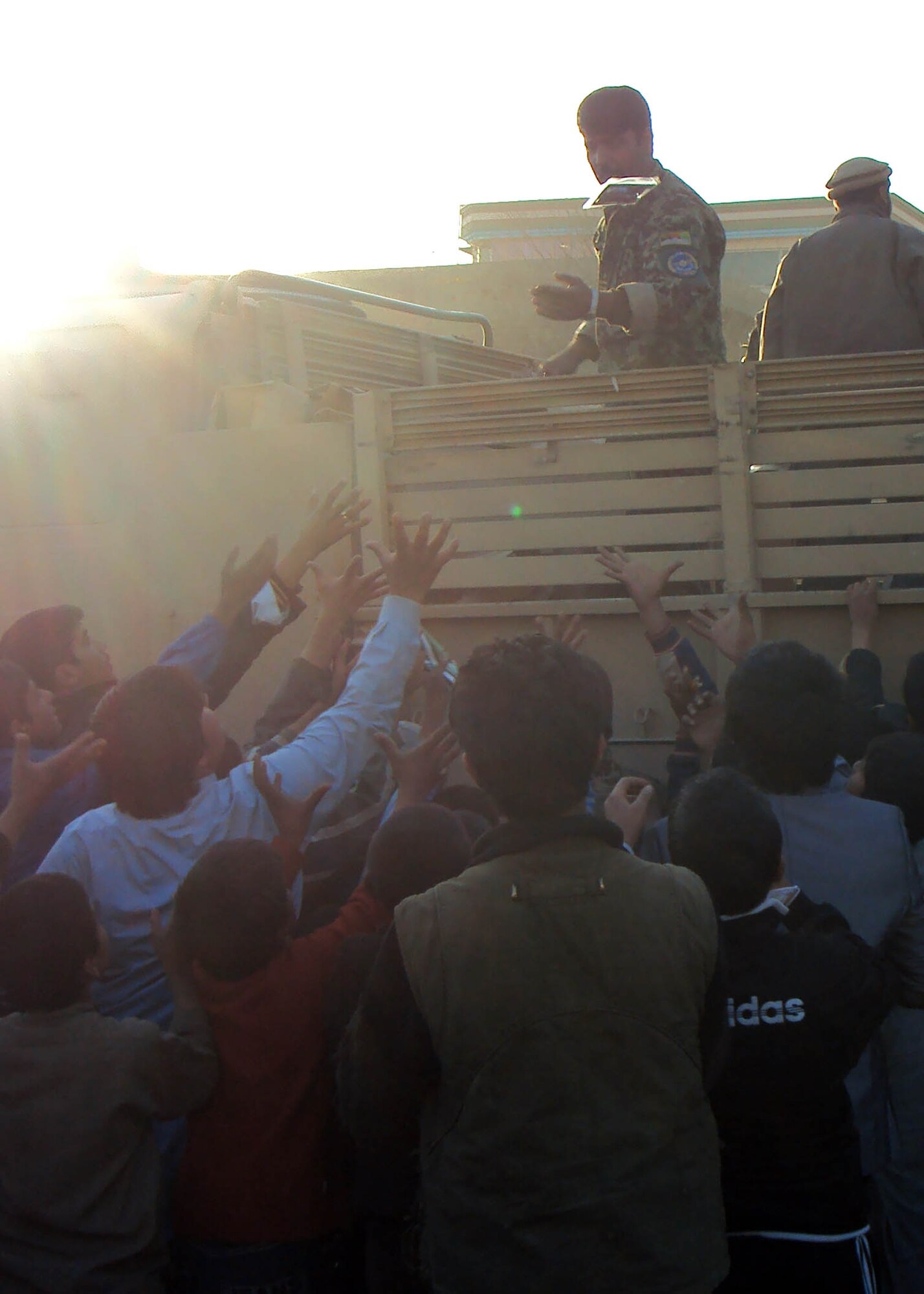 101202-N-6541W-024 KABUL, Afghanistan - Members of the Afghan Air Force and NATO Air Training Command - Afghanistan advisors distribute humanitarian aid supplies to a local neighborhood in Kabul, Afghanistan on Dec. 2nd. (U.S. Navy photo by Mass Communication Specialist 3rd Class Jared Walker/ RELEASED).