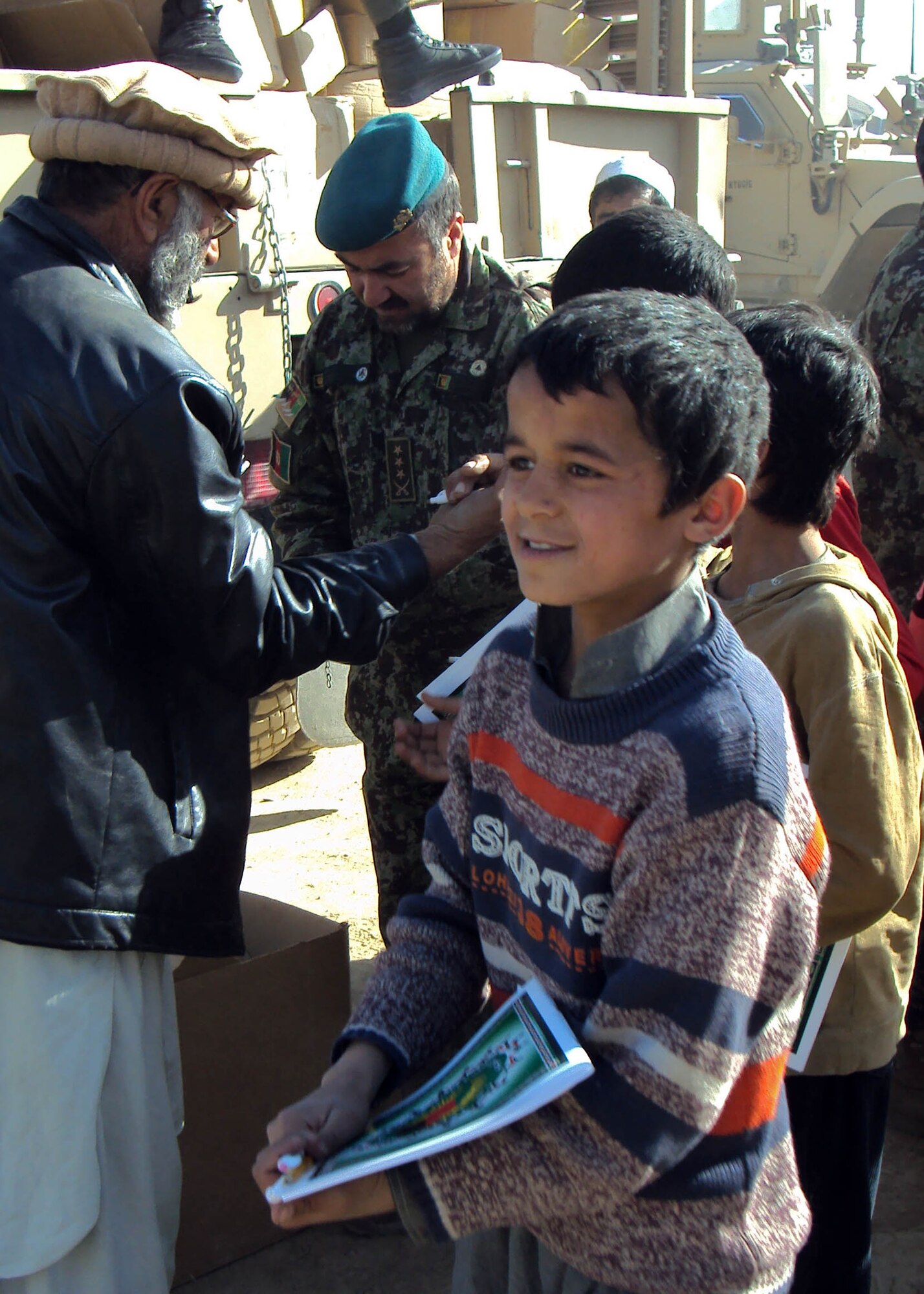 101202-N-6541W-024 KABUL, Afghanistan - Members of the Afghan Air Force and NATO Air Training Command - Afghanistan advisors distribute humanitarian aid supplies to Mohammad Faquil Ferozi school in Kabul, Afghanistan on Dec. 2nd. (U.S. Navy photo by Mass Communication Specialist 3rd Class Jared Walker/ RELEASED).
