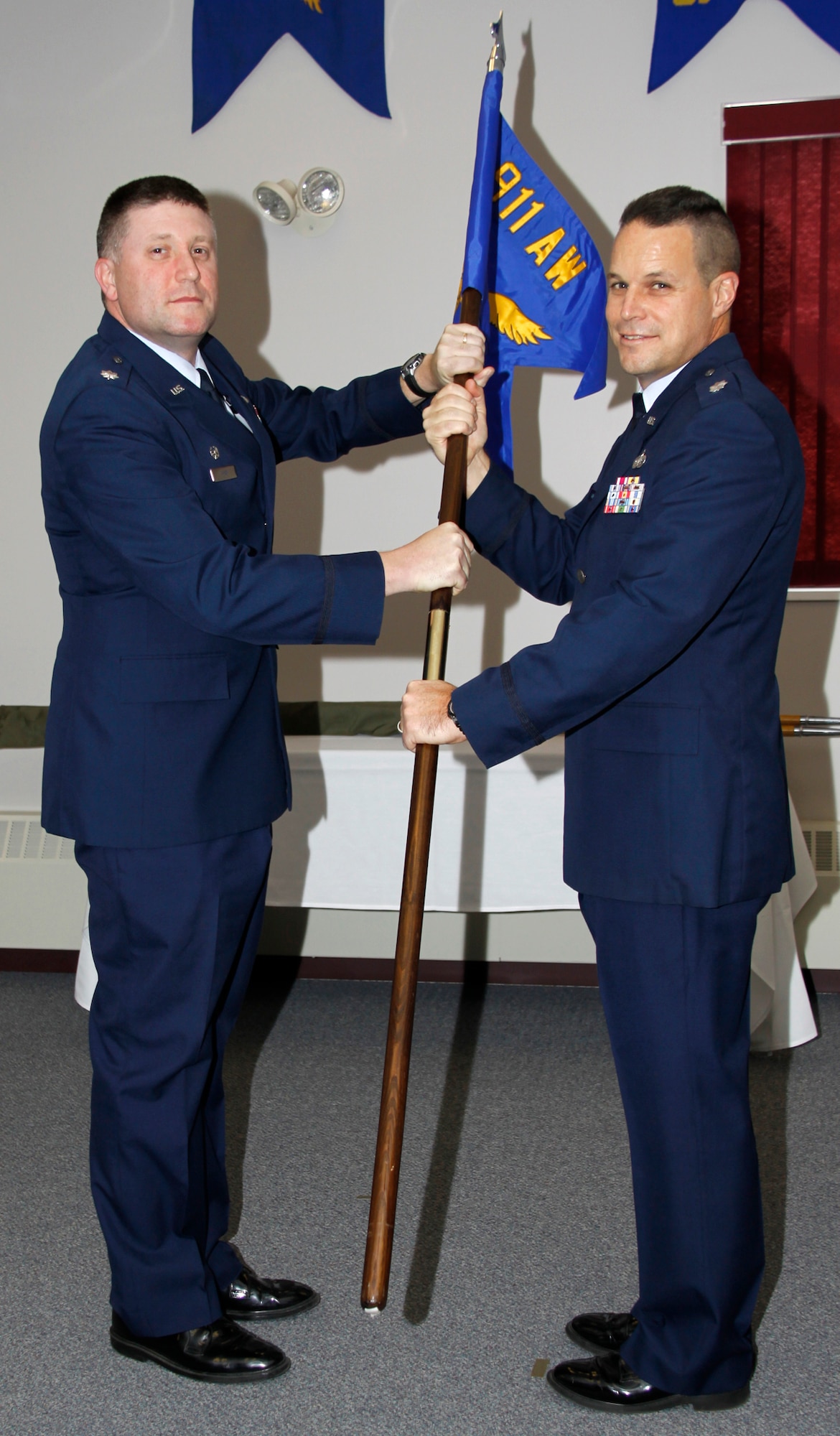 911th Mission Support Group Commander, Lt. Col. Patrick S. Ryan(left) hands the 911th Force Support Squadron guidon to Lt. Col. Lowell Bingham to signify the standup of the new squadron.