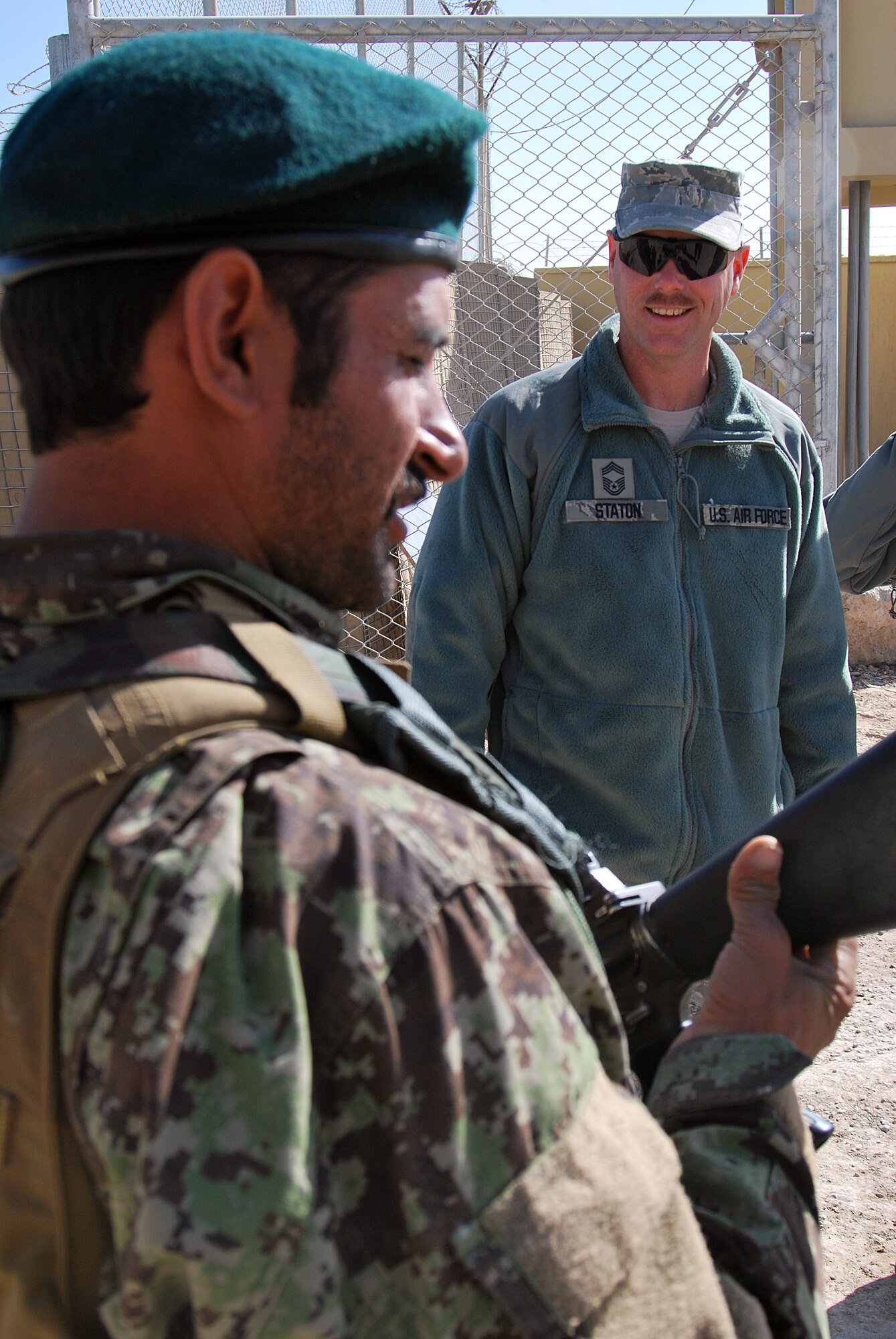 Chief Master Sgt. Dave Staton talks to an Afghan Security Forces Airman about his weapon Dec. 1 at Kandahar Airfield, Afghanistan. Chief Staton is the 738th Air Expeditionary Advisory Group superintendent. As the senior enlisted member, he is also the direct mentor to the Kandahar Air Wing?s enlisted leader, Command Sgt. Maj. Mohammad Hassan. (U.S. Air Force photo by Senior Airman Melissa B. White/Released)