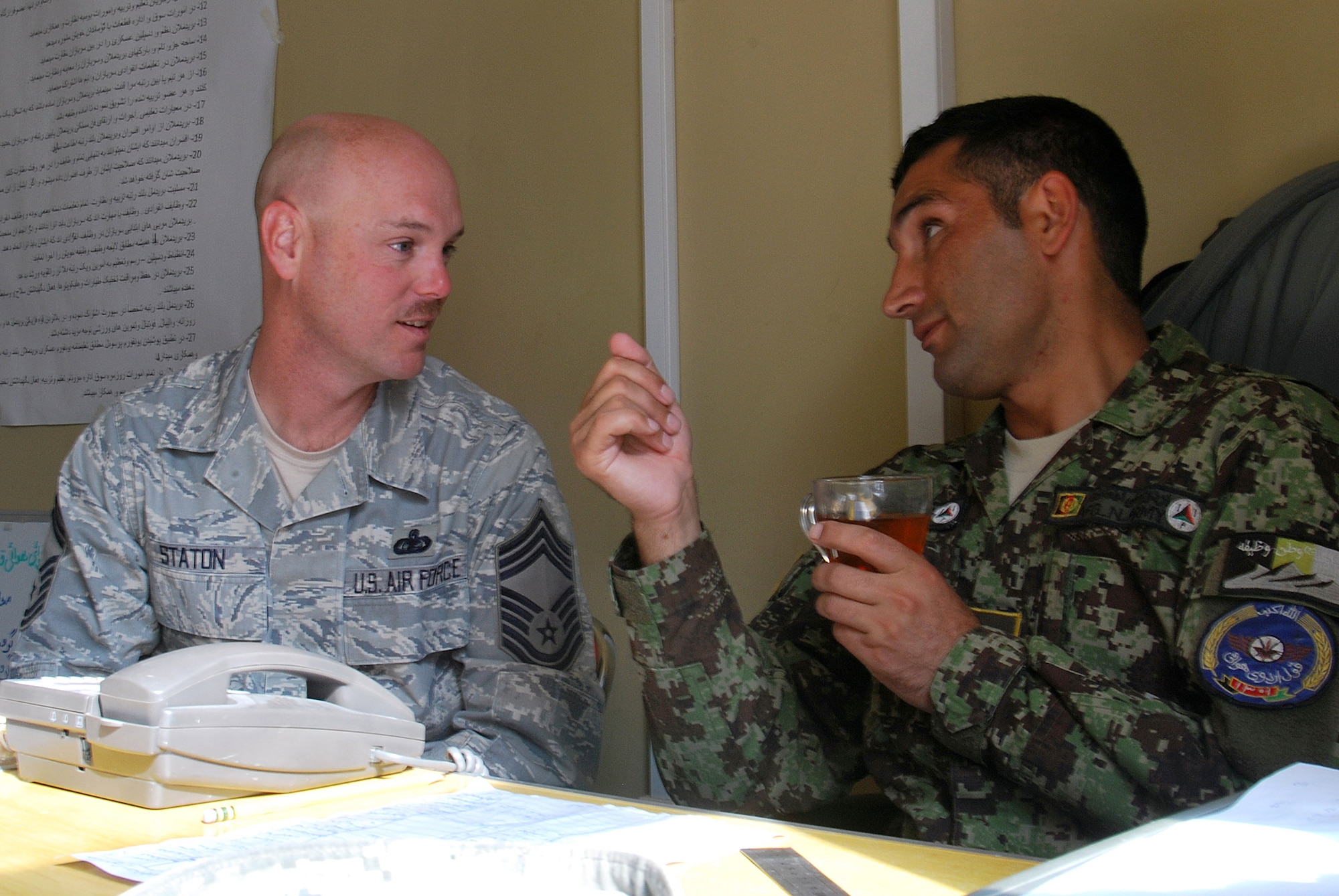 Chief Master Sgt. Dave Staton and Afghan Air Force Command Sgt. Maj. Mohammad Hassan talk during a meeting Dec. 1 at Kandahar Airfield, Afghanistan. Chief Staton is the 738th Air Expeditionary Advisory Group superintendent. As the senior enlisted member, he is also the direct mentor to the Kandahar Air Wing?s enlisted leader, Sergeant Major Hassan. (U.S. Air Force photo by Senior Airman Melissa B. White/Released)