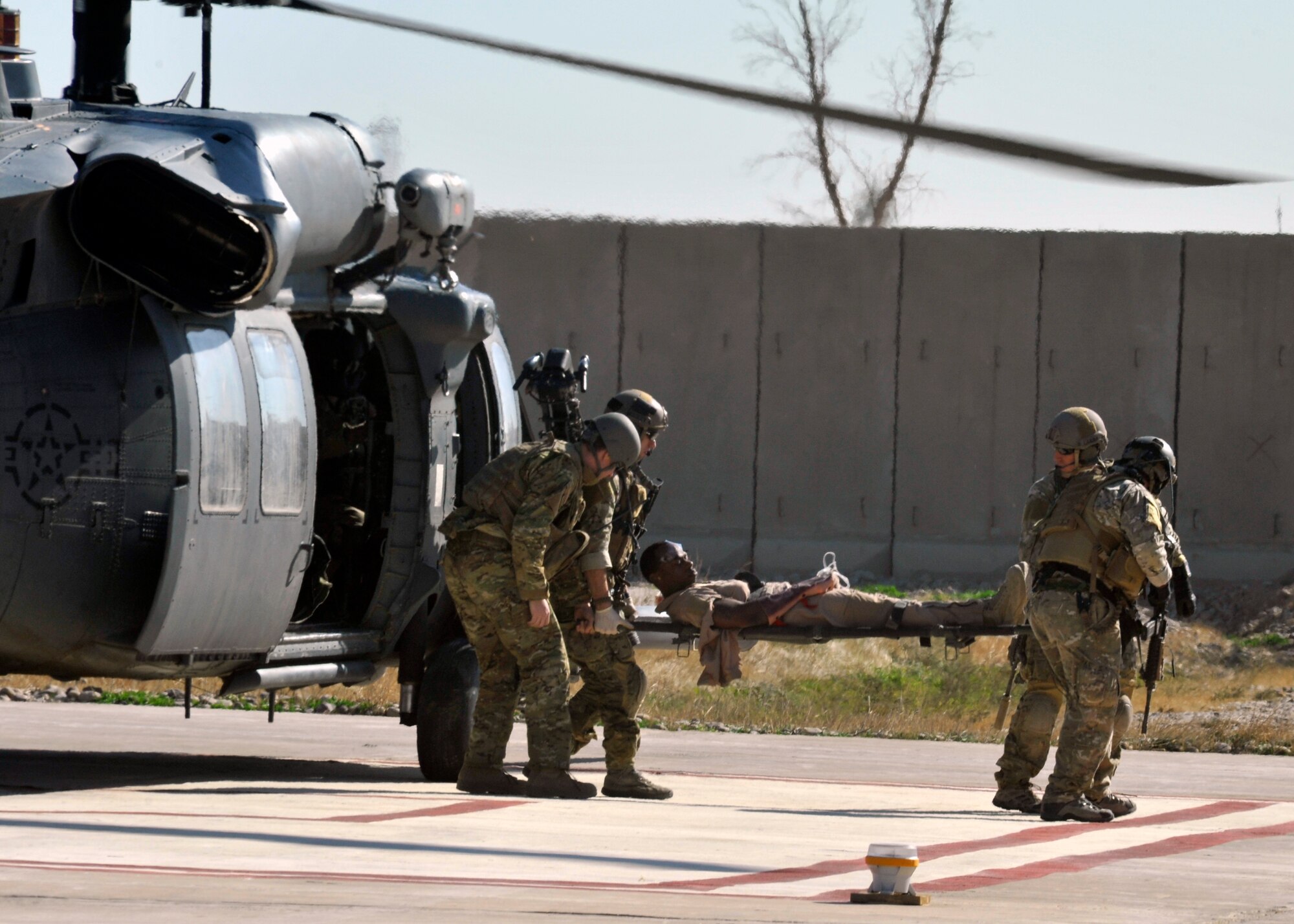JOINT BASE BALAD, Iraq – Pararescue jumpers from the 64th Expeditionary Rescue Squadron offload a simulated patient from an HH-60G Pavehawk helicopter at the Air Force Theater Hospital helo pad during an exercise Dec. 2, 2010.  The exercise was part of training for the pararescue teams to prepare them for missions during their deployment here. (U.S. Air Force photo/ Tech. Sgt. Stacy Fowler) 