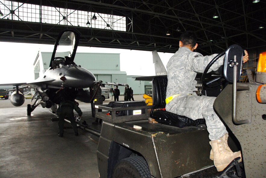 U.S. Air Force Airman 1st Class Hector Arrayo, 35th Aircraft Maintenance Squadron crew chief, tows an F-16 Fighting Falcon into a Komatsu Air Self-Defense Force Base hangar for protection from inclement weather during a Keen Sword 2011 exercise mission Dec. 3, 2010. During Keen Sword 2011, units from the United States Army, Navy, Air Force and Marine Corps, will conduct training with their Japan Self-Defense Force counterparts at military installations throughout mainland Japan, Okinawa and in the waters surrounding Japan. (U.S. Air Force photo by 1st Lt. Cammie Quinn/ Released)