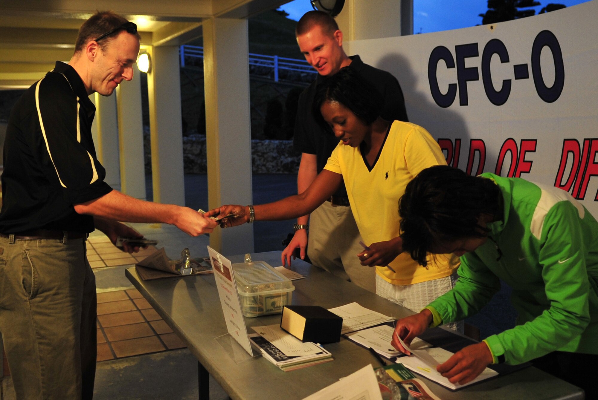 A golfer registers with Wing CFC coordinators Capt. Reagan Beaton and Senior Master Sgt. Stephanie Baker and 18th Dental Squadron representative Master Sgt. Francesca Seehausen at the Combined Federal Campaign golf tournament at the Banyan Tree golf course Dec. 3. More than 80 golfers participated in the CFC golf tournament. (U.S. Air Force photo/Staff Sgt. Alesia Goosic)