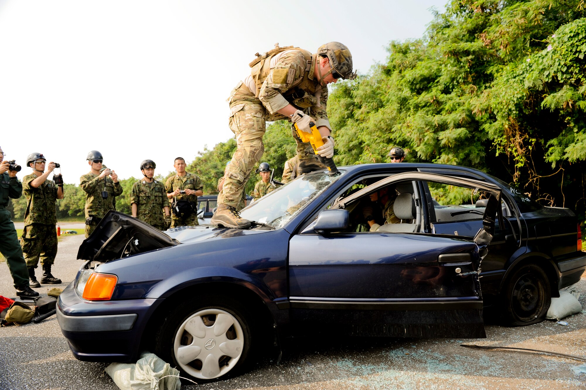 United Stated Air Force Staff Sgt. Matt Ritchie, 31st Rescue Squadron, a pararescue man cuts through a windshield during vehicle extraction training Dec. 3. The extraction training was part of Keen Sword to bring together United States Air Force and Japan Self-Defense Forces pararescue men to train and share techniques on vehicle extraction. Keen Sword is designed to allow the United States and Japan to practice and evaluate the coordination procedures and interoperability elements required to effectively and mutually respond to the defense of Japan, or to a regional crisis or contingency situation in the Asia-Pacific region, while building bilateral confidences and working relationships. .(U.S. Air Force photo/Staff Sgt. Jonathan Steffen)