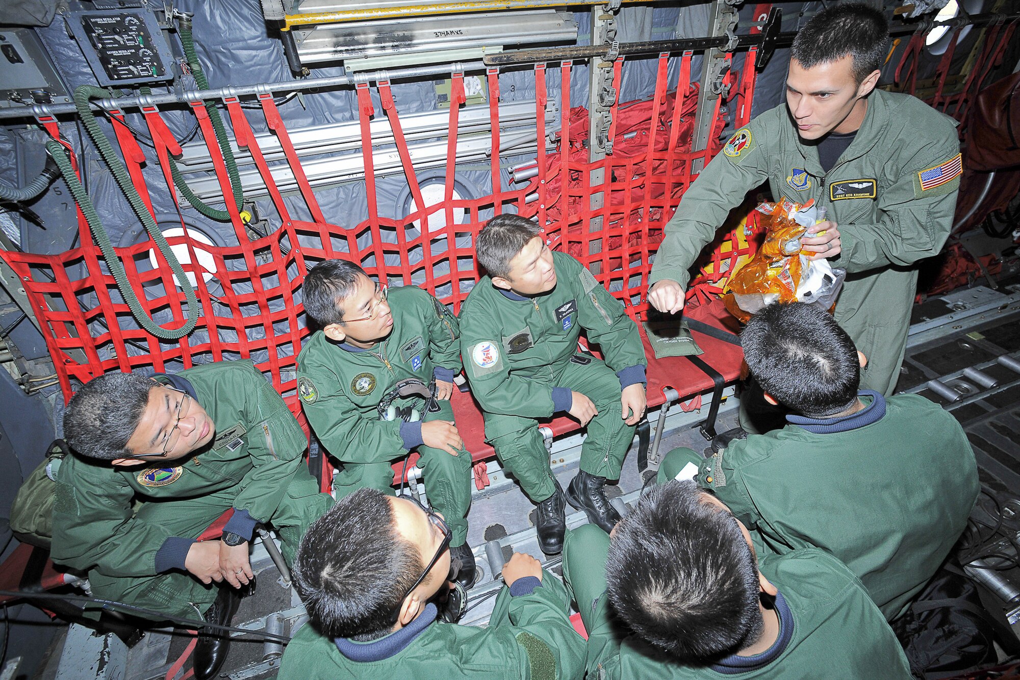 YOKOTA AIR BASE, Japan -- Staff Sgt. Cravenkeo Khamone, 36th Airlift Squadron, explains emergency procedures to the members from Japan Air-Self Defense Force here Dec. 3 during the joint-bilateral training exercise Keen Sword 2011. (U.S. Air Force photo/Osakabe Yasuo)   