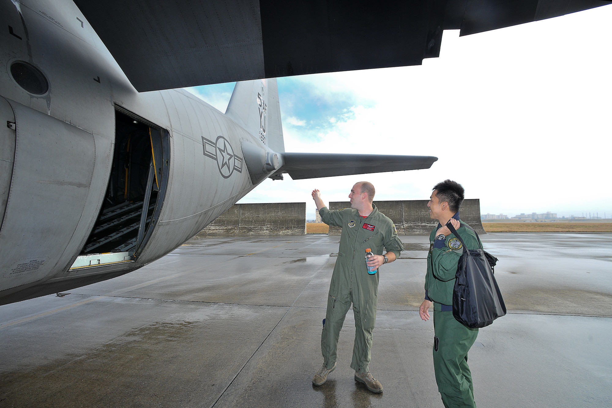 YOKOTA AIR BASE, Japan -- Airman 1st Class Noel Jones (left), 36th Airlift Squadron, introduces a C-130 Hercules to Capt. Yoshitomo Morii (right), 3rd Tactical Airlift Wing from Miho Air Base, here Dec. 3 during the joint-bilateral training exercise Keen Sword 2011. (U.S. Air Force photo/Osakabe Yasuo)