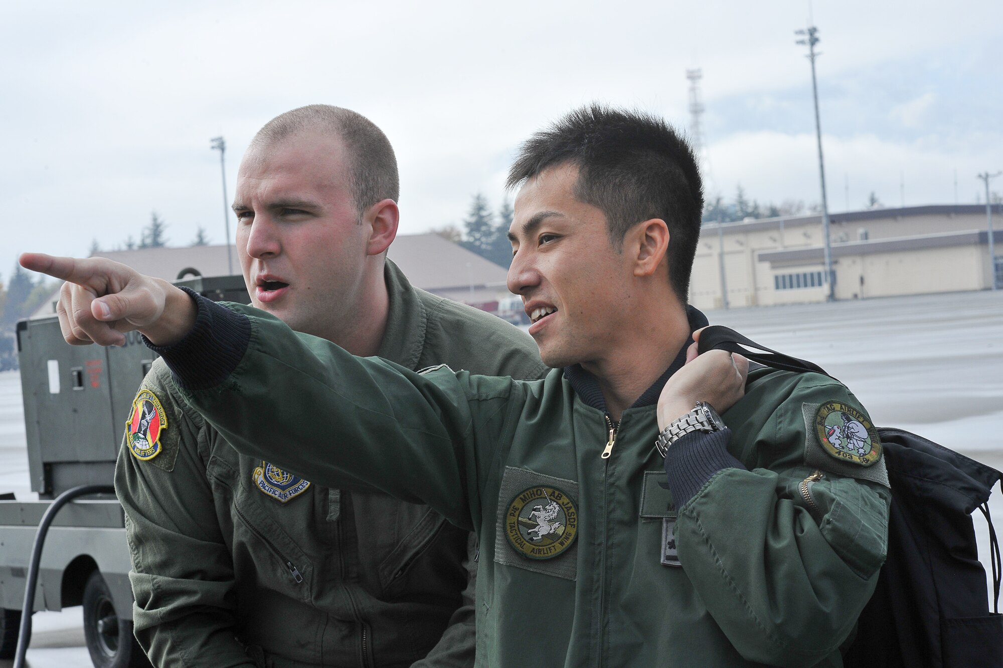 YOKOTA AIR BASE, Japan -- Capt. Yoshitomo Morii (right), 3rd Tactical Airlift Wing, asks Airman 1st Class Noel Jones, 36th Airlift Squadron, about C-130 Hercules operations here Dec. 3 during the joint-bilateral training exercise Keen Sword 2011. (U.S. Air Force photo/Osakabe Yasuo)