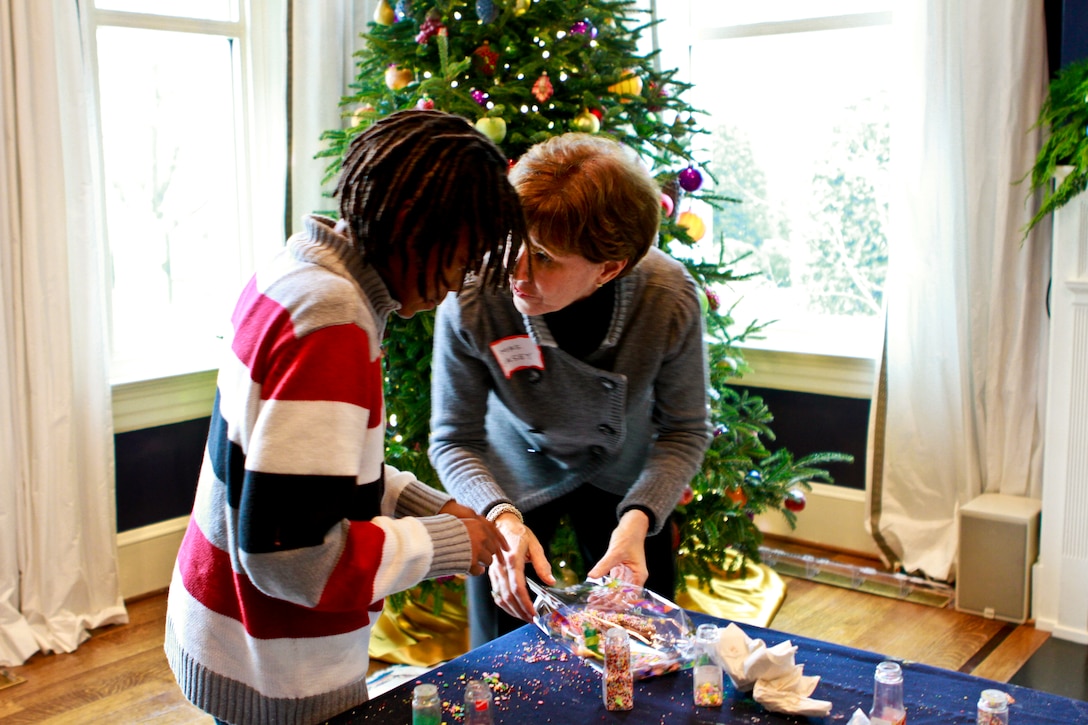 Shiela Casey, wife of Army Chief of Staff Gen. George W. Casey Jr. converses over cookies with a child at a holiday event hosted by Dr. Jill Biden, wife of Vice President Joe Biden, at their home at the Naval Observatory in Washington, D.C., Dec. 1, 2010.