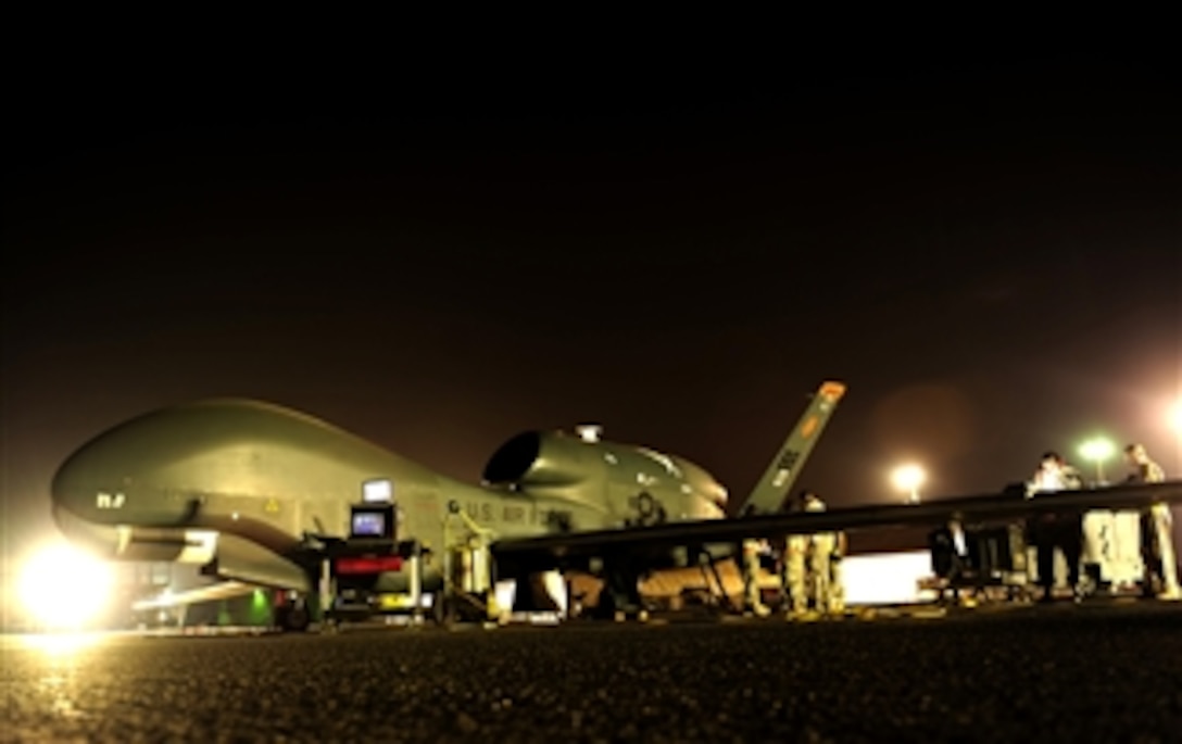 An RQ-4 Global Hawk unmanned aircraft gets prepared for a mission while deployed at an air base in Southwest Asia.  The RQ-4 and the airmen are assigned to the 380th Expeditionary Operations Group.  