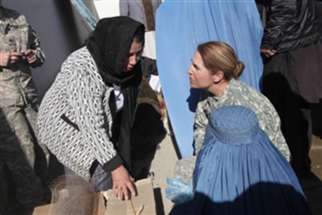 U.S. Army Maj. Bobbie Mayes (right), the women's empowerment coordinator for the Kentucky Agribusiness Development Team, and a teacher with the Agency for Building a New Afghanistan (left) review supplies that will be given to Afghan widows at the Director of Women's Affairs compound in Kapisa province, Afghanistan, on Nov. 30, 2010.  Twenty-five Afghan widows who completed a five-day poultry class received nine hens, a rooster, food and supplies.  