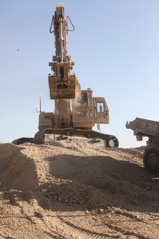 Lance Cpl. Josh Davis, a heavy equipment operator with Heavy Equipment Platoon, Support Company, 8th Engineer Support Battalion, 1st Marine Logistics Group (Forward), fills a dump 7-ton while helping to build a landing pad, on Forward Operating Base Nolay, Dec 3. The landing pad will be used for a blimp that has a camera attached to it and will keep a protective watch over Marines in the area.
