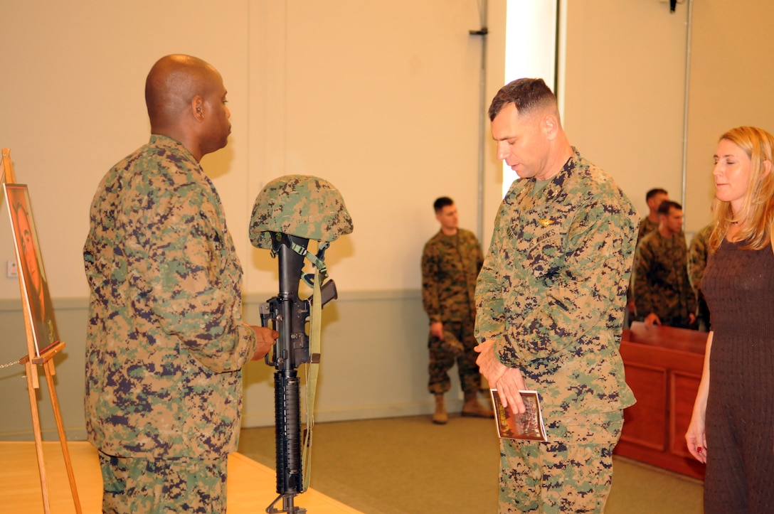 Col. Anton Nerad, Marine Aircraft Group 13 commanding officer, pays his respects at a memorial service for Sgt. Elvis Acosta, Marine Aviation Logistics Squadron 13 aviation supply technician, at the Marine Corps Air Station in Yuma, Ariz., Dec. 3, 2010. The Tampa, Fla., native died in a motorcycle accident on Thanksgiving day. He is survived by his wife Alma and three children Melanie, Melissa and Elvis. Funeral services will be held at St. Mary Catholic Parrish in El Centro, Calif., Dec. 9, 2010.
