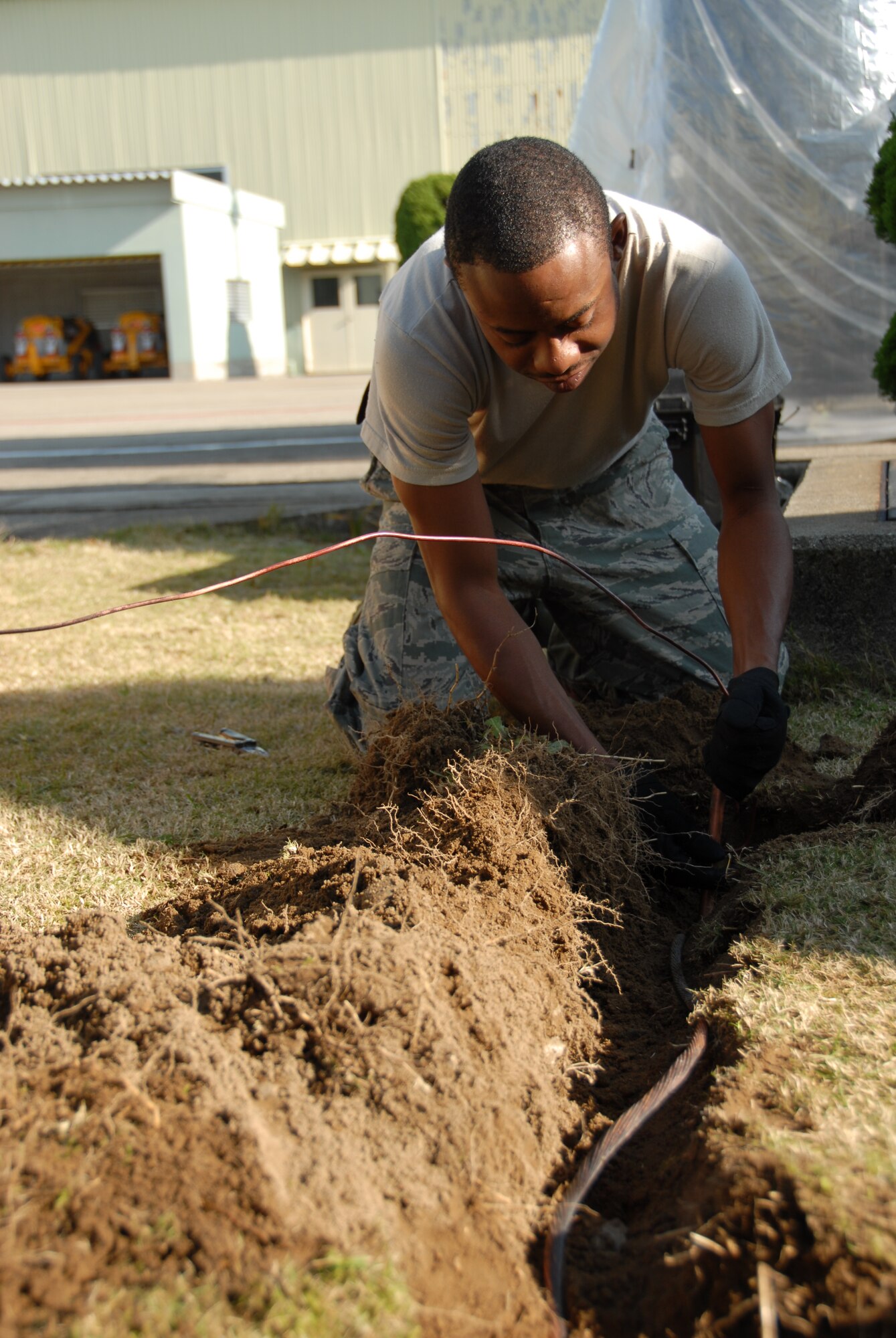 U.S. Air Force Staff Sgt. Albert Turner, 644th Combat Communications Squadron, lays grounding in a hole to protect communication equipment at Komatsu Air Self-Defense Force Base, Japan, Dec. 1, 2010. Members from the 644 CBCS are working at Komatsu JASDF Base in support of the joint, bilateral exercise, Keen Sword 2011. Keen Sword is a regularly scheduled exercise that strengthens Japan-U.S. military interoperability and meets mutual defense objectives. Japan-U.S. military operations and exercises increase readiness to respond to varied crisis situations. (U.S. Air Force photo by 1st Lt. Cammie Quinn/ Released)
