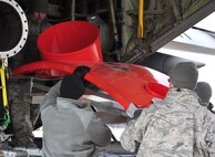 Members of the Air Force Reserve's 39th Aerial Port Squadron help to load a modified C-130 Hercules paratroop door onto an aircraft Dec. 4 at Peterson Air Force Base, Colo. The Airmen were supporting last-minute loading of the U.S. Forest Service Modular Airborne Fire Fighting System equipment and accessories as part of a 302nd Airlift Wing deployment to Israel to help battle raging wildfires there. The wing, the only aerial firefighting organization in the AF Reserve, received its orders late Dec. 3 to ready approximately 50 personnel and two aircraft to deploy on short notice to help fight a more than 7,000 acre fire burning out of control near Israel's third-largest city, Haifa. (U.S. Air Force photo/Staff Sgt. Stephen J. Collier)