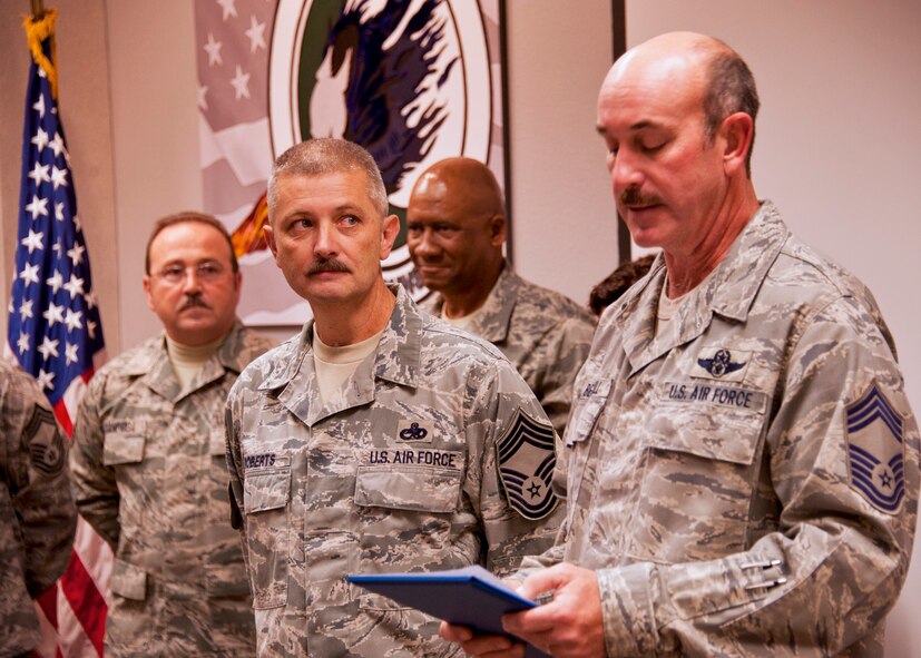 Newly inducted Chief Master Sgt. James Roberts, 919th Maintenance Group, listens intently as Chief Master Sgt. Dale Berryhill, 711th Special Operations Squadron, reads the chief master sergeant oath during the induction ceremony Dec. 4 at Duke Field.   (U.S. Air Force photo/Tech. Sgt. Samuel King Jr.)