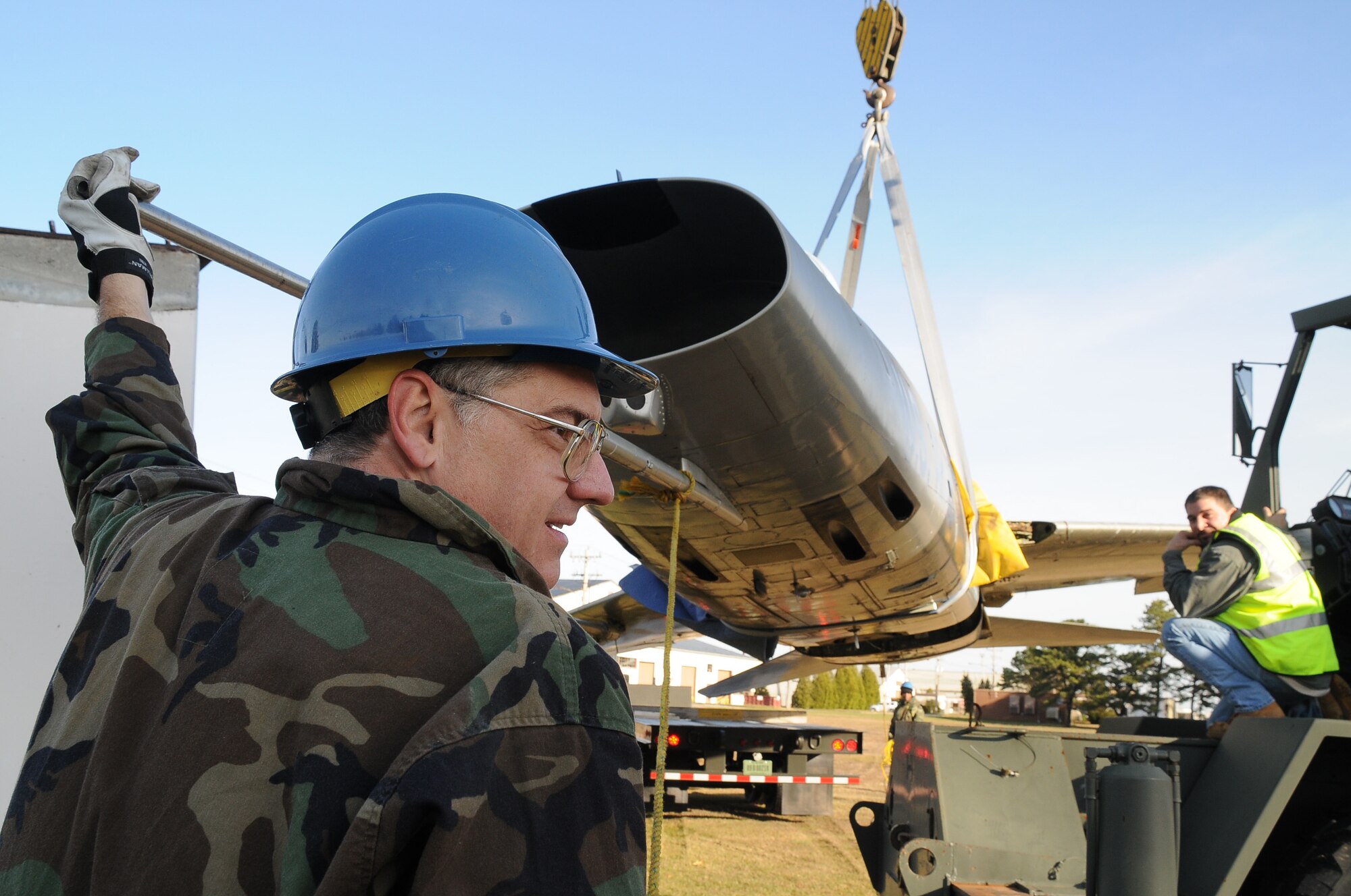 Erwin Ross, exhibit specialist in aircraft restoration from the Museum of Aviation, Robbins Air Force Base, Georgia, assists the 102d Intelligence Wing Civil Engineers with the removal of an F-100 static aircraft to be shipped back to Robbins AFB for future restoration and display.