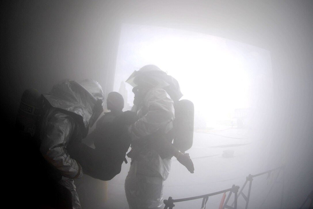 932nd Airlift Wing firefighters search a smoke-filled building to find a "survivor" mannequin and take him from a simulated fire outside to fresh air during an exercise.  (U.S. Air Force photo/Tech. Sgt. Chris Parr)