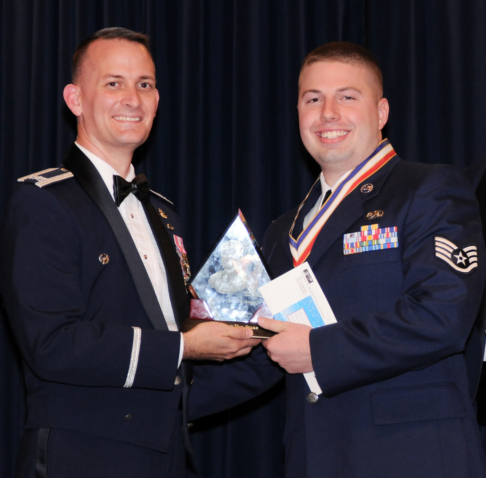 YOKOTA AIR BASE, Japan - Colonel Bill Knight, 374th Airlift Wing vice commander, presents Staff Sgt. Jeff Van Stone, 374th Maintenance Squadron, the John L. Levitow Award as the top graduate of class 11-A, during the Airman Leadership School graduation ceremony held at the Yokota Enlisted Club here Dec. 2. (U.S. Air Force photo/ Airman 1st Class Katrina R. Menchaca)