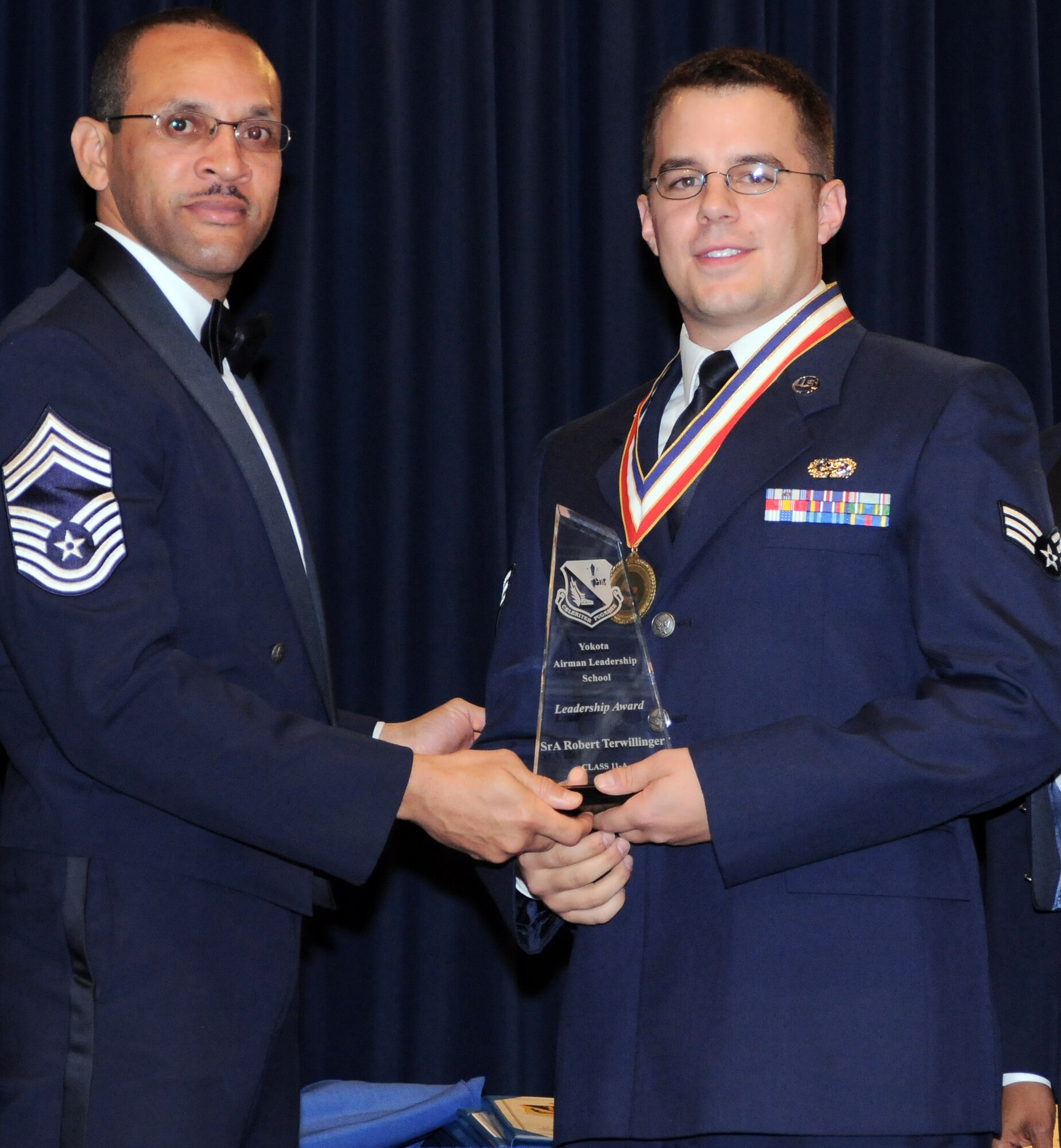 YOKOTA AIR BASE, Japan - Chief Master Sgt. Roosevelt Neely, 374th Communications Squadron superintendent, presents the Leadership Award to Senior Airman Robert Terwilliger, 374th CS, during the Airman Leadership School graduation ceremony here Dec. 2.  (U.S. Air Force photo/ Airman 1st Class Katrina R. Menchaca)