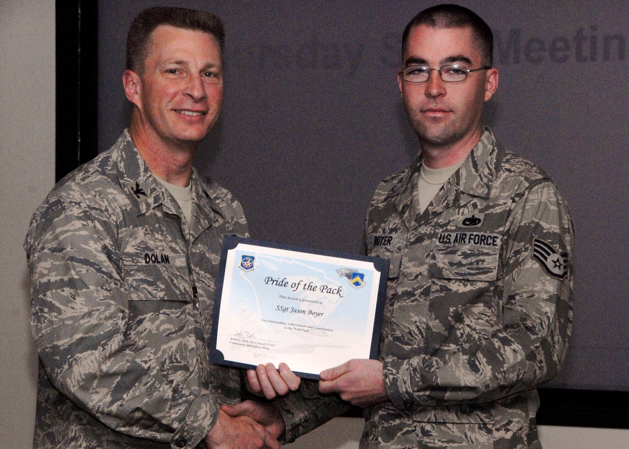 KUNSAN AIR BASE, Republic of Korea -- Col. John Dolan, 8th Fighter Wing commander, presents Staff Sgt. Jason Boyer, 8th Maintenance Squadron transient alert, with a Pride of the Pack award Dec. 3. (U.S. Air Force photo/Capt. Sheryll Klinkel)
