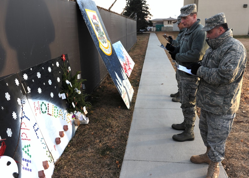 KUNSAN AIR BASE, Republic of Korea -- Chief Master Sgt. James Sanders, 8th Fighter Wing command chief, Col. John Dolan, 8th Fighter Wing commander, and Col. Hugh Hanlon, 8th Fighter Wing vice commander judges holiday greeting cards at the tree lighting ceremony here Dec. 3, 2010. The 8th Force Support Squadron came in first place, with the 8th Medical Group placing in second and 8th Security Forces Squadron in third. (U.S. Air Force photo/Senior Airman Ciara Wymbs) 