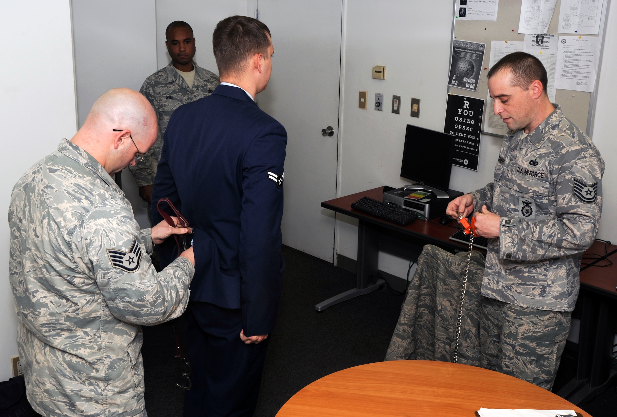 U.S. Air Force Staff Sgt. Ross List, left, 35th Security Forces Squadron, NCO in charge of Customs and Confinement, and Tech. Sgt. Michael Montgomery, right, 35th SFS, NCO in charge of Vehicle Search, put restraints on a detainee  as he is taken into custody at Misawa Air Base, Japan, Nov. 29, 2010. Misawa is one of the few bases in the Air Force confinement facility. (U.S. Air Force photo by Tech. Sgt. Russell McBride/Released)