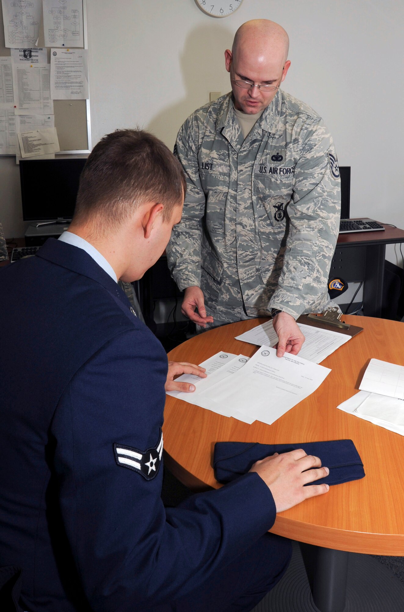 U.S. Air Force Staff Sgt. Ross List, center, 35th Security Forces Squadron NCO in charge of Customs and Confinement, processes a detainee, left, during the initial phase of confinement at Misawa Air Base, Japan, Nov. 29, 2010. It takes an average of six to seven hours for the certified security forces member to process the inmate. (U.S. Air Force photo by Tech. Sgt. Russell McBride/Released)