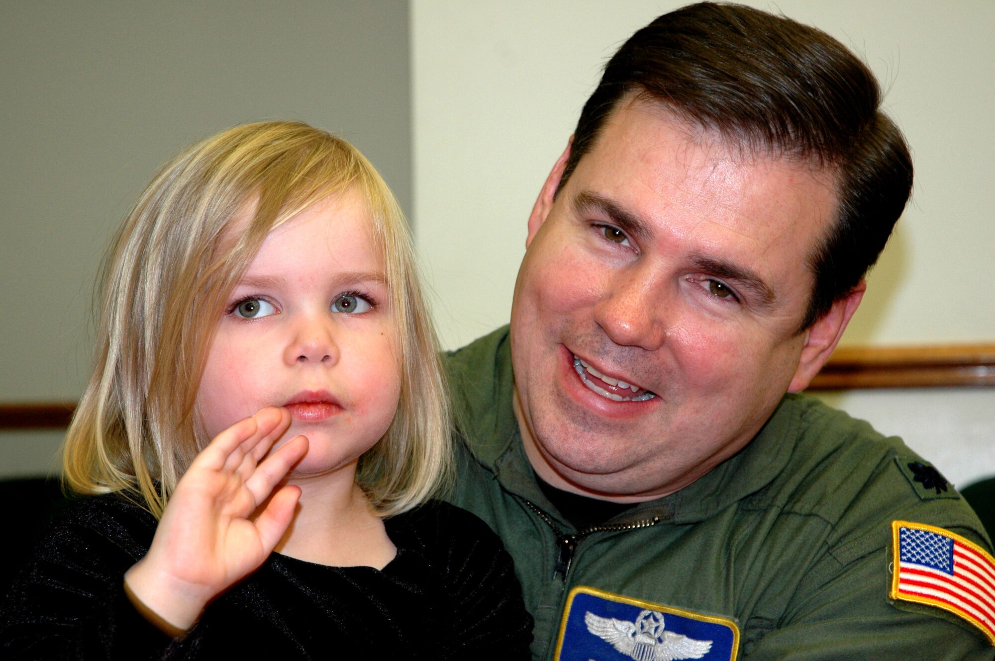JOINT BASE LEWIS-MCCHORD, Wash.- Four-year-old Kiah and dad, Lt. Col. Rob Sawyer, pilot resource manager with the 728th Airlift Squadron enjoy the holiday music as they wait for Santa to drop by during the squadron's holiday party, Dec. 4 in the 446th Operations Group Auditorium. Kiah said all she wants for Chirstmas is another kitten to add to her litter of three. The 446th Airlift Wing held several unit holiday parties this weekend to herald in the holiday season. (U.S. Air Force Photo/Staff Sgt. Nicole Celestine)