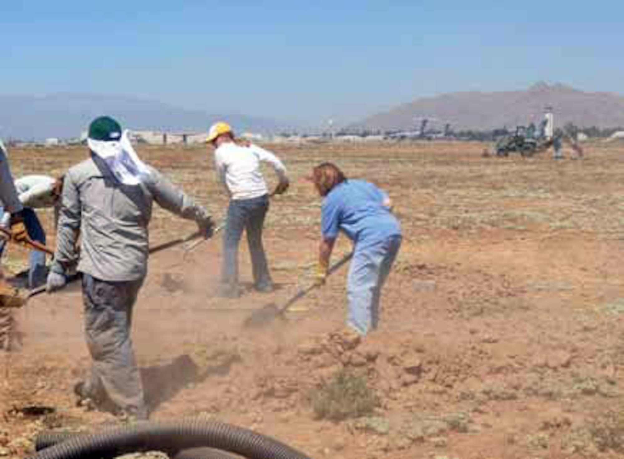 In the heat of the Inland Empire day, Sept. 1, a team of volunteers helps Dr. Jeffrey Lincer (far left) bury the drainage pipe tunnels. (U.S. Air Force photo by Megan Just)
