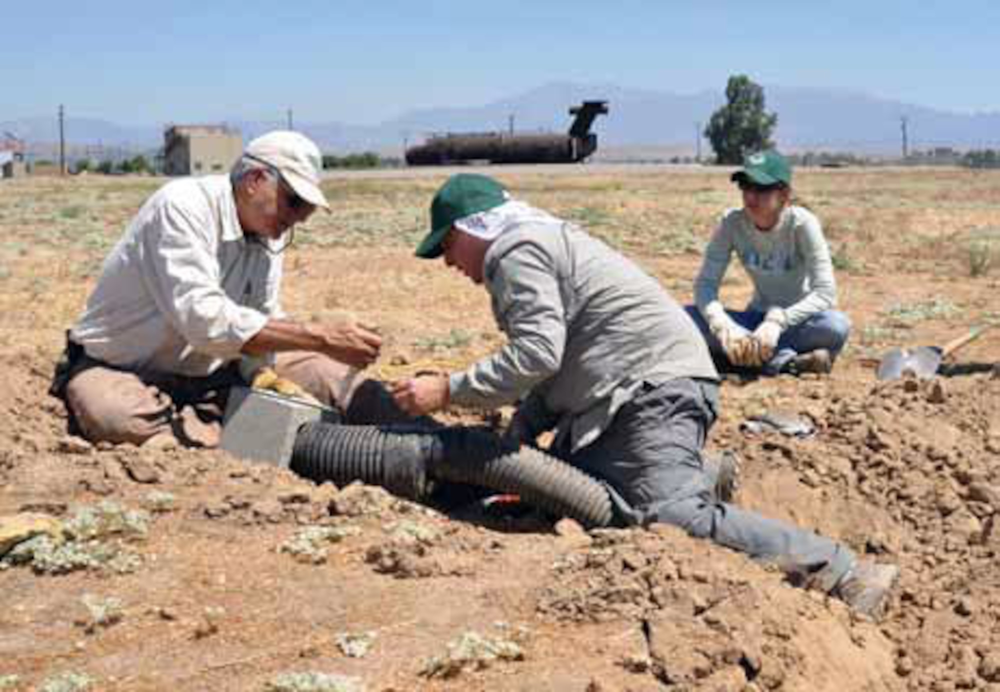 Daniel Palmer, a volunteer, helps Dr. Jeffrey Lincer fit drainage pipe into a cinderblock. (U.S. Air Force photo by Megan Just)

