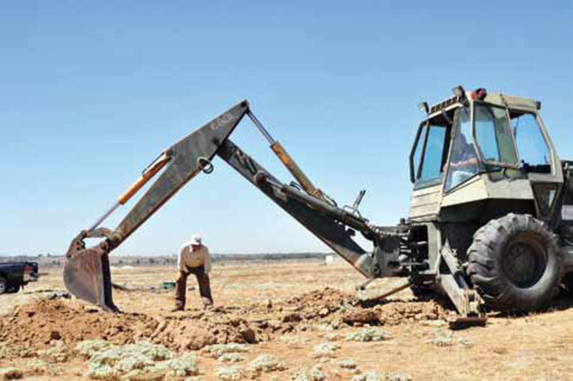 Todd Strahl, SSI, uses a backhoe to dig Sept. 1 while Dr. Jeffrey Lincer advises him on depth. They dug six burrow clusters. (U.S. Air Force photo by Megan Just)

