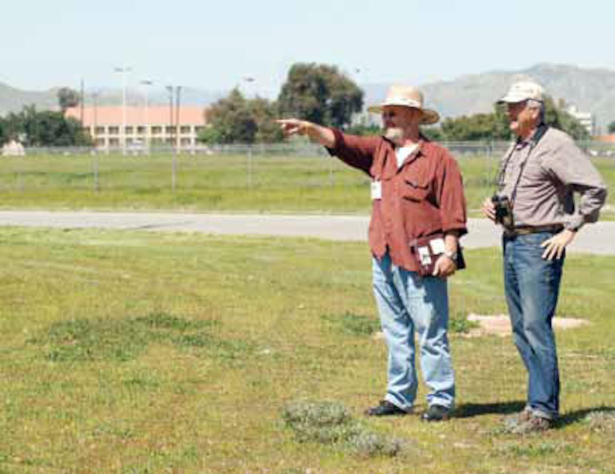452nd Environmental Flight acting natural resources manager Gerald Haas (left) shows raptor ecologist Dr. Jeffrey Lincer the location of an active burrowing owl nest, March 19, on the site of the proposed indoor firing range. (U.S. Air Force photo by Megan Just)
