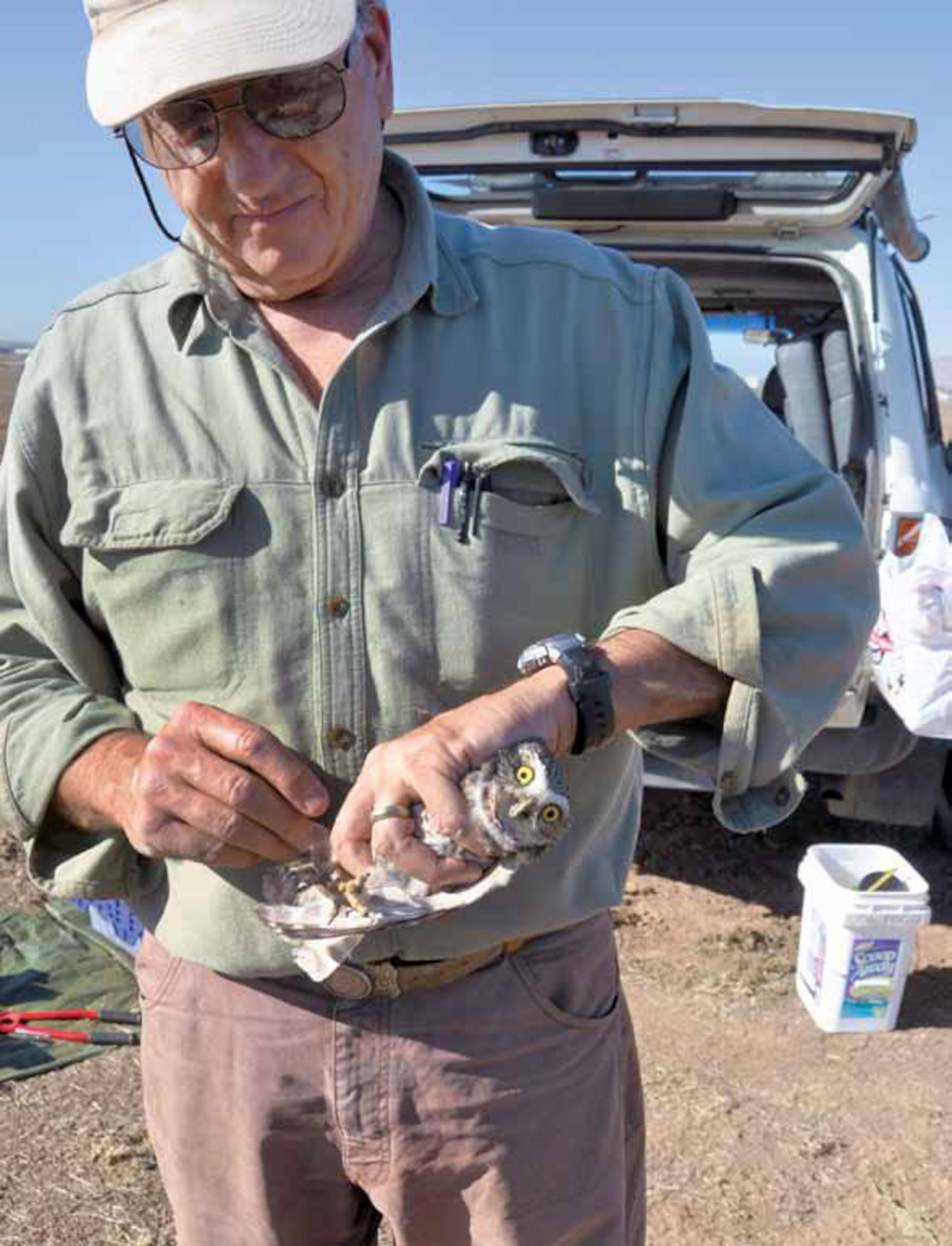 Dr. Jeffrey Lincer, prepares to band a burrowing owl just before releasing it to a cage above its new burrow on the base, Nov. 17. (U.S. Air Force photo by Megan Just)
