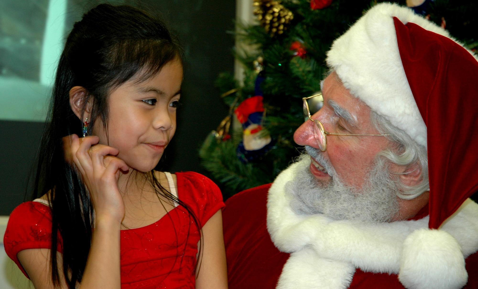 JOINT BASE LEWIS-MCCHORD, Wash.- 10-year-old Arianna Tiangco was all smiles as she sits on Santa's lap and tells him what she'd like as presents, during Santa's visit to the 728th Airlift Squadron's holiday party, Dec. 4 in the 446th Operations Group Auditorium. Arianna is the granddaughter of Lita Tiangco, 728th AS aviation resource management civilian. The 446th Airlift Wing held several holiday parties this weekend to herald in the holiday season. (U.S. Air Force Photo/Staff Sgt. Nicole Celestine)